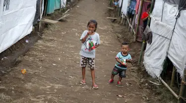 Anak-anak bermain di sekitar tenda Posko Pengungsi Rendang, Bali, Sabtu (2/12). Erupsi Gunung Agung membuat anak-anak tersebut terpaksa harus bermain di posko pengungsian dengan kondisi yang seadanya. (Liputan6.com/Immanuel Antonius)