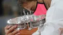 Petenis Rafael Nadal memegang trofi saat merayakan kemenangannya atas Novak Djokovic pada final Prancis Terbuka 2020 di Stadion Roland Garros, Paris, Prancis, Minggu (11/10/2020). Dengan kemenangan ini, Nadal menyamai rekor Roger Federer dengan meraih 20 gelar Grand Slam. (AP Photo/Christophe Ena)