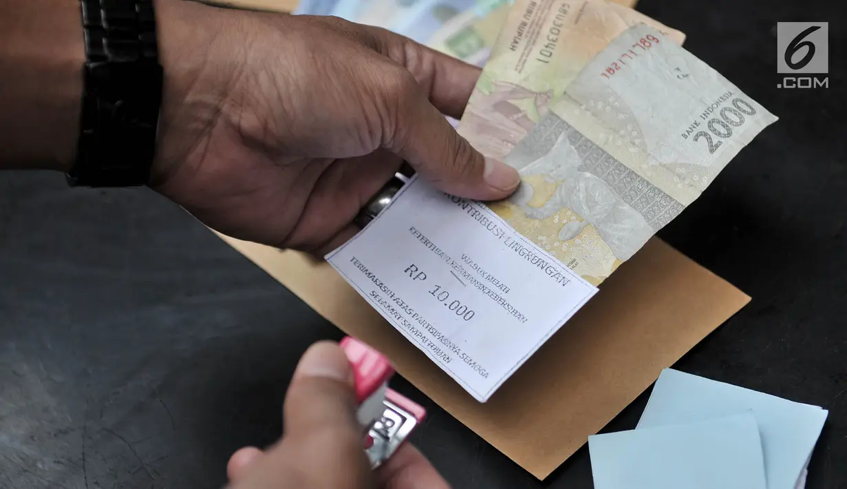 Polisi merapihkan barang bukti saat rilis kasus retribusi dan parkir liar di Mapolsek Tanah Abang, Jakarta, Senin (4/6). Dalam kasus ini polisi juga mengamankan barang bukti berupa uang tunai sebesar Rp 722.500. (Merdeka.com/Iqbal S Nugroho)