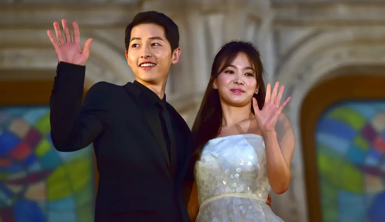 Song Joong Ki dan Song Hye Kyo melambaikan tangan ketika berpose di karpet merah The 52nd Baeksang Art Awards di Seoul, 3 Juni 2016. Melalui agensi masing-masing, Song-Song Couple mengumumkan pernikahan mereka pada 31 Oktober 2017. (JUNG YEON-JE/AFP)