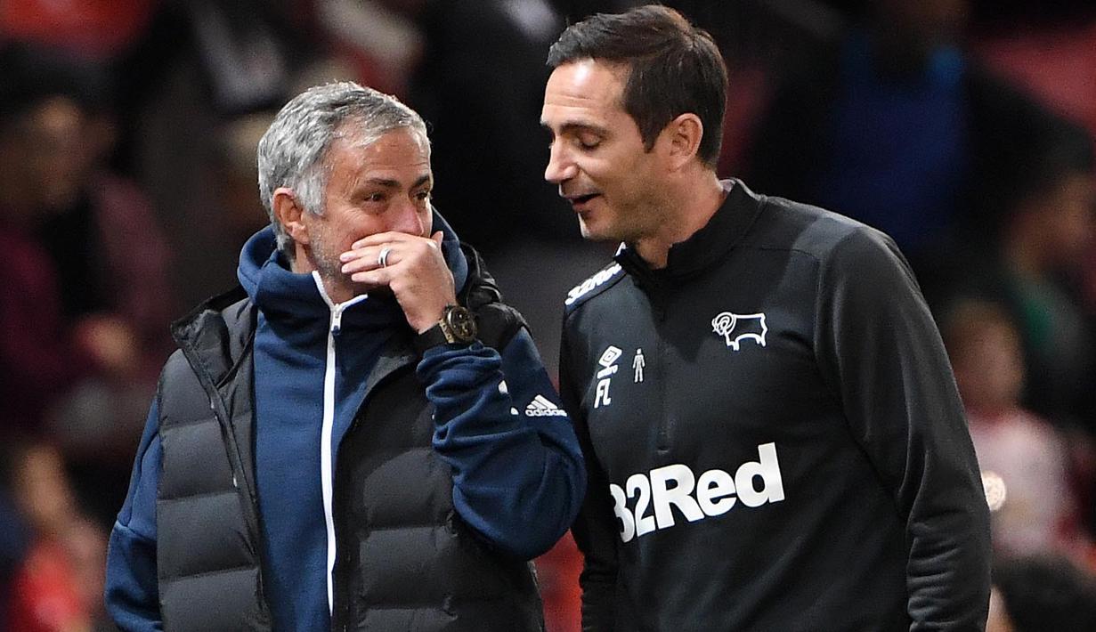 Pelatih Derby County, Frank Lampard, berbincang dengan pelatih Manchester United, Jose Mourinho, pada Piala Liga Inggris di Stadion Old Trafford, Rabu (26/9/2018). Manchester United takluk adu penalti 9-10 (2-2) dari Derby County. (AFP/Paul Ellis)