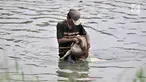 Aktivitas pencari cacing super di Kanal Banjir Timur, Jakarta, Kamis (14/2). Pak Sum (57) bersama kedua rekannya dari Bekasi setiap hari berburu cacing super di sepanjang aliran Kanal Banjir Timur. (Merdeka.com/Iqbal Nugroho)