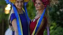 Maria (kiri) mengenakan topi bermotif bendera Ukraina berpose dengan Anastasia saat foto pada hari pertama pertemuan balap kuda Royal Ascot, di Ascot Racecourse, di Ascot, Inggris, Selasa (14/6/2022). (AP Photo/Alastair Grant)