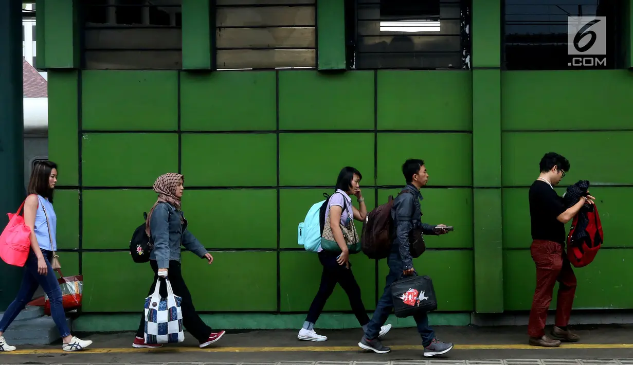 Sejumlah calon penumpang membawa barang bawaannya hendak menaiki kereta di Stasiun Gambir, Jakarta, Rabu (29/11). (Liputan6.com/JohanTallo)