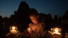 Lucretia Martinez (7) menyalakan lilin untuk mengenang korban penembakan di sekolah Santa Fe, Texas, Amerika serikat, Jumat (18/5). Sebanyak 10 orang tewas dalam tragedi penembakan tersebut. (AFP)