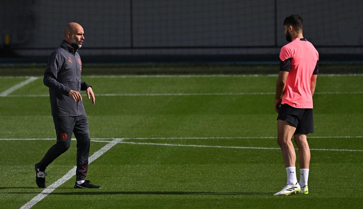 Pelatih Manchester City, Pep Guardiola (kiri) berbicara kepada pemainnya, Josko Gvardiol saat memimpin sesi latihan timnya di Manchester City Training Ground, Manchester (18/9/2023) waktu setempat, jelang menghadapi Red Star Belgrade pada matchday pertama Grup G Liga Champions 2023/2024 di Etihad Stadium, Rabu (20/9/2023) dini hari WIB. (AFP/Paul Ellis)
