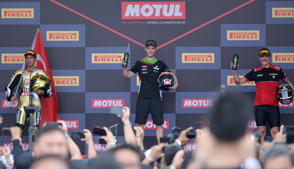 Pembalap Pata Yamaha Toprak Razgatlioglu (kiri), pembalap Kawasaki Racing Team Jonathan Rea (tengah), dan pembalap Aruba Racing Scott Redding berdiri di podium usai Race 1 WSBK Mandalika 2021 di Pertamina Mandalika International Street Circuit, Lombok, Nusa Tenggara Barat, Minggu (21/11/2021).
