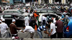 Demonstran memanfaatkan air botol untuk wudhu salat Jumat, di sekitar Halte Juanda, Jakarta, Jumat (4/11). Karena seluruh bagian masjid Istqlal penuh, sebagian massa gelar salat Jumat di sekitar Jalan Ir. H. Juanda. (Liputan6.com/Gempur M. Surya)