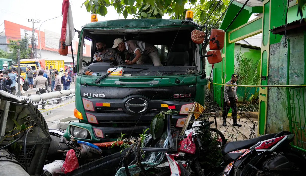 Polisi mencoba memindahkan truk setelah kecelakaan lalu lintas di Bekasi, Indonesia, Rabu (31/8/2022). Sebanyak 10 orang dilaporkan meninggal dunia dalam kecelakaan maut tersebut. (AP Photo/Achmad Ibrahim)