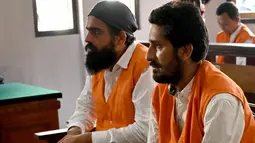 Dua WN India, Manjeet Singh (kanan) dan Harvinder Singh menjalani sidang di Pengadilan Denpasar, Bali, Kamis (19/12/2019). Manjeet Singh (32) dan Harvinder Singh (26)  didakwa dengan menyelundupkan 2,7 kilogram sabu ke Bali dan terancam hukuman maksimal pidana mati. (SONNY TUMBELAKA / AFP)