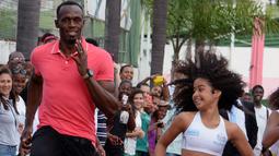 2.	Sprinter Jamaika juara Olimpiade,Usain Bolt, berlomba dengan anak-anak saat mengunjungi kompleks olah raga Mangueira, Rio de Janeiro, Brasil. Jumat (16/4)