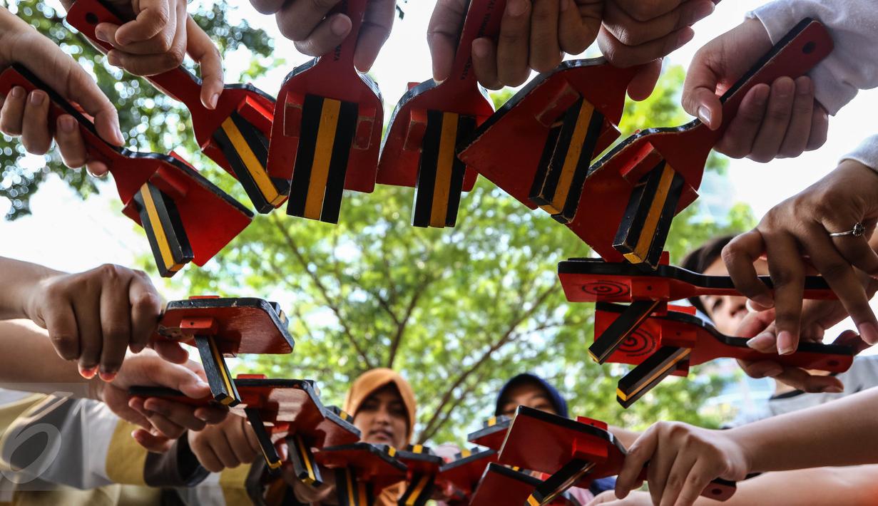 Sejumlah anak muda yang tergabung dalam komunitas Hyakka Ryouran membentuk lingkaran dengan alat musik asal Jepang, Naruko, di kawasan Senayan, Jakarta, Minggu (24/7). Naruko dipergunakan saat mengiringi Tarian Yosakoi. (Liputan6.com/Fery Pradolo)