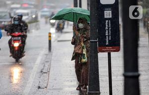 Pejalan kaki menggunakan payung saat hujan deras di kawasan Thamrin, Jakarta, Rabu (23/11/2022). Kepala Pelaksana Badan Penanggulangan Bencana Daerah (BPBD) DKI Jakarta Isnawa Adji mengimbau masyarakat untuk mengurangi aktivitas di luar rumah apabila Jakarta mengalami cuaca ekstrem. (Liputan6.com/Faizal Fanani)