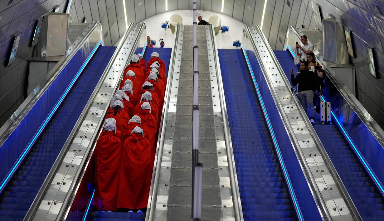 Pengunjuk rasa yang mendukung hak-hak perempuan berpakaian seperti karakter dari serial TV "The Handmaid's Tale" saat melakukan perjalanan untuk memprotes rencana pemerintah baru Perdana Menteri Benjamin Netanyahu untuk merombak sistem peradilan di sebuah stasiun kereta api di Yerusalem, Israel, 1 Maret 2023. Mengacu pada fenomena yang berkembang, harian Inggris The Guardian menggambarkan penampilan para pelayan sebagai salah satu simbol paling kuat dari protes feminis kontemporer. (AP Photo/Ohad Zwigenberg)