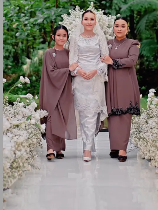 Syifa mengenakan baju kurung lengan panjang dengan kerah tinggi dan bordiran hitam di bagian lengan dan bawah dipadukan rok satin panjang dan mules heels hitam.  Ditambah aksesori bros dan kalung silver. [@aliencophoto]