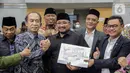 Menteri Agama Yaqut Cholil Qoumas (tengah) bersalaman dengan Ketua Komisi VIII DPR RI, Ashabul Kahfi (kedua kiri) seusai menandatangani draft penetapan biaya haji 2023 di kompleks Parlemen, Senayan, Jakarta, Rabu (15/2/2023). Kementerian Agama bersama Komisi VIII DPR selesai menggelar rapat panja biaya haji 2023. Pemerintah bersama legislator menyepakati biaya haji yang harus dibayarkan jemaah sebesar Rp 49.812.700. (Liputan6.com/Faizal Fanani)