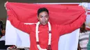 Pelari muda Indonesia, Lalu Muhammad Zohri membentangkan bendera Merah Putih saat penyambutan di Terminal 3 Bandara Soetta, Tangerang, Selasa (17/7). Lalu M Zohri meraih emas 100m putra di Kejuaraan Dunia Atletik U-20. (Liputan6.com/Helmi Fithriansyah)