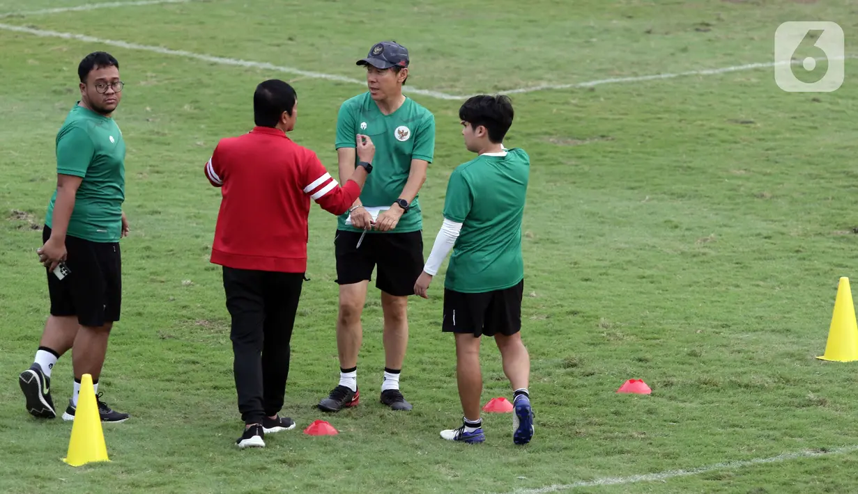 Pelatih Timnas U-19 Indonesia, Shin Tae-yong (bertopi) berbicara dengan Direktur Teknik PSSI, Indra Sjafri disela-sela memimpin latihan di Lapangan A Gelora Bung Karno, Jakarta, Selasa (30/8/2022). Shin Tae-yong alan menyeleksi 36 pemain yang akan dikerucutkan menjadi 23-26 pemain. (Liputan6.com/Helmi Fithriansyah)