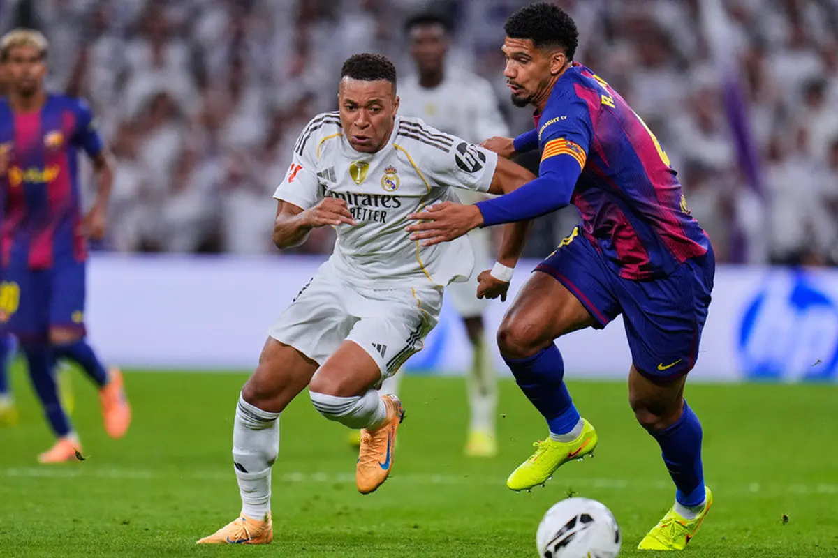 Kylian Mbappe dari Real Madrid berebut bola dengan Ronald Araujo dari Barcelona