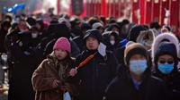 Sepasang suami istri makan sosis bakar saat orang bermasker mengunjungi pameran kuil pada hari kedua perayaan Tahun Baru Imlek di Taman Yuanmingyuan, Beijing, China, Senin (23/1/2023). Tahun Baru Imlek adalah hari libur tahunan terpenting di China. (AP Photo/Andy Wong)