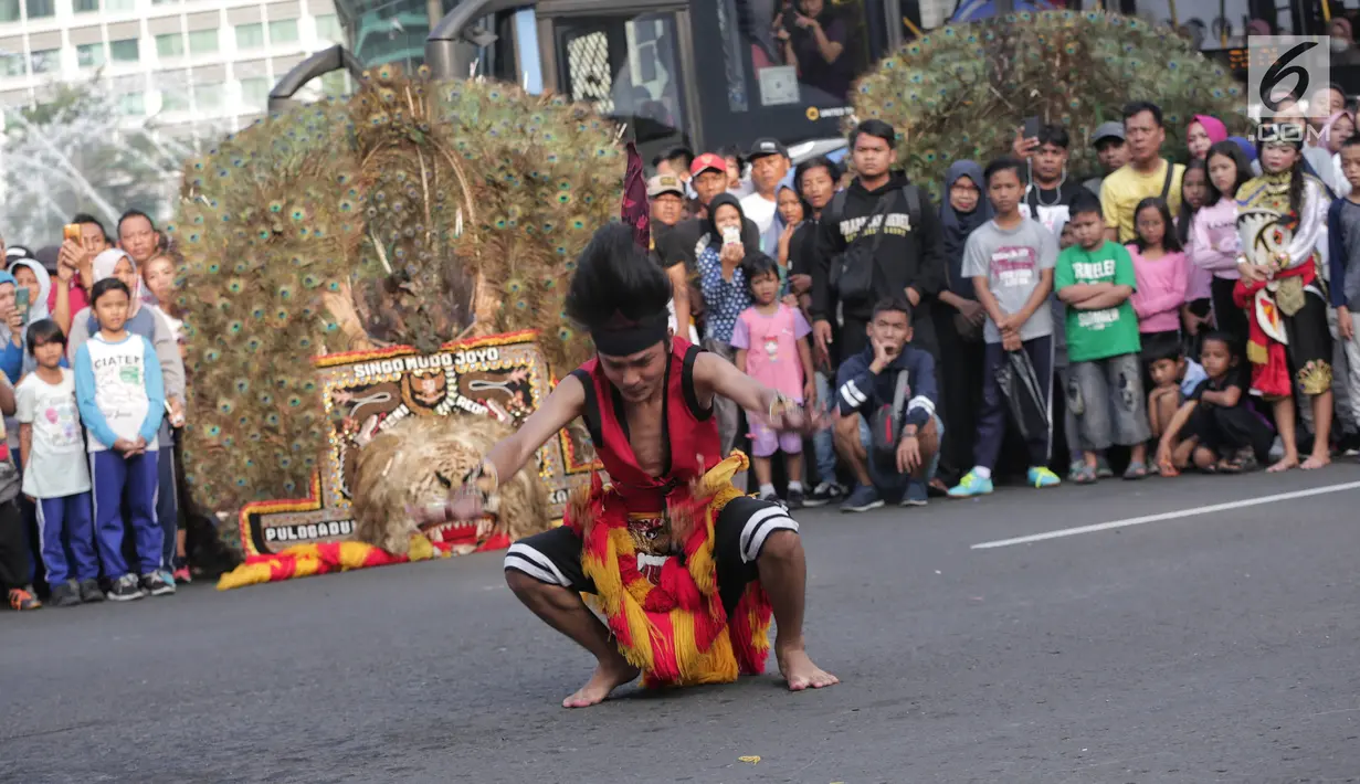 Seniman melakukan atraksi saat pertunjukan Tari Reog Ponorogo di area car free day kawasan Bundaran Hotel Indonesia (HI), Jakarta, Minggu (28/4/2019). Kegiatan untuk memperingati Hari Kartini tersebut turut diramaikan oleh sejumlah polisi wanita (polwan). (Liputan6.com/Faizal Fanani)