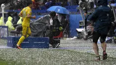 Pemain Ukraina, Yevhen Konoplyanka (kiri) berlari menghindari terjangan hujan batu es saat melawan Irlandia Utara  pada laga grup C  Euro 2016 di Stadion Parc Olympique Lyon, Kamis ( 16/6/2016) WIB. AFP/Philppe Desmazes)