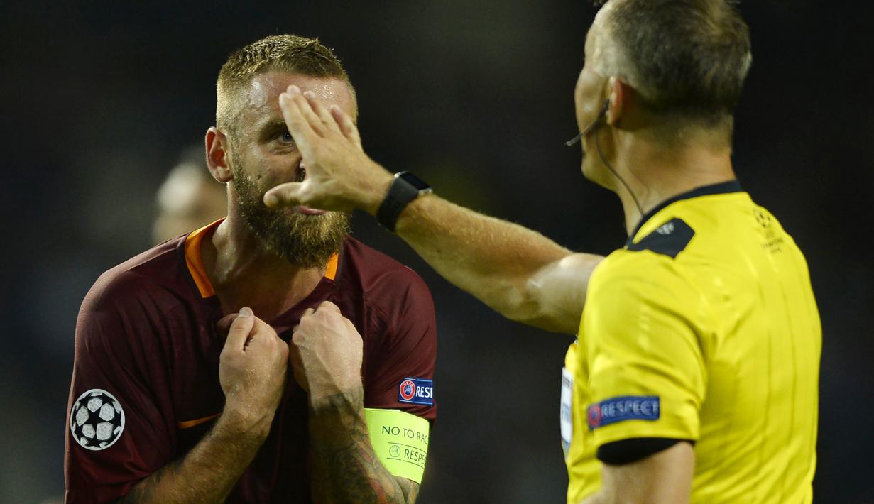 Kapten AS Roma, Daniele De Rossi (kiri) memprotes keputusan wasit, Bjorn Kuipers saat laga melawan FC Porto pada leg pertama  playoff Liga Champions 2016-2017 di Estadio Do Dragao, Kamis (18/8/2016) dini hari WIB. (AFP/Miguel Riopa)