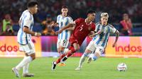 Pemain Timnas Indonesia, Marselino Ferdinan (tengah kanan) berebut bola dengan pemain Argentina, Alejandro Garnacho pada laga FIFA Matchday di Stadion Utama Gelora Bung Karno (SUGBK), Senayan, Jakarta, Senin (19/06/2023). (Bola.com/Bagaskara Lazuardi)