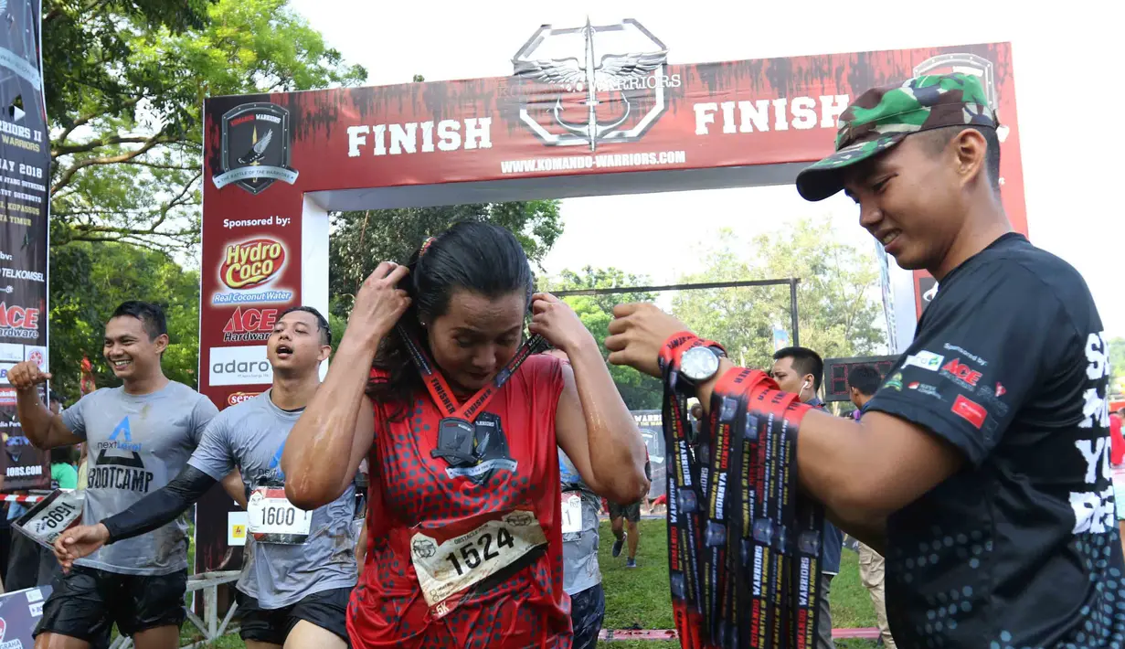 Panitia memberikan medali pada peserta yang tiba di garis finish dalam ajang Komando Warriors II di Kompleks Kopassus Cijantung, Jakarta, Minggu (6/5). (Liputan6.com/Angga Yuniar)