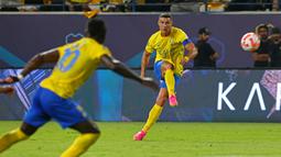 Pemain Al Nassr, Cristiano Ronaldo (kanan), menendang bola ke gawang Al Taawon dalam laga pekan ke-2 Liga Arab Saudi 2023/2024 yang berlangsung di KSU Football Stadium, Sabtu (19/8/2023) dini hari WIB. Al Nassr mencatatkan percobaan tembakan dibabak pertama, tapi hanya dua yang tepat sasaran. (AFP/Fayez Nureldine)