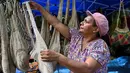 <p>Bentuk bilum sepintas mirip dengan bentuk tas noken Papua. Bilum merupakan tas rajutan tradisional yang dikenakan kebanyakan perempuan di Papua Nugini. Bilum memiliki ciri khas berbagai warna dan corak sesuai dengan daerah asal bilum dibuat. (ADEK BERRY/AFP</p>