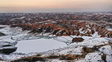 Foto dari udara yang diabadikan pada 3 Desember 2020 ini menunjukkan pemandangan Mahuangliang Loess Geopark usai turun salju di Kota Yulin, Provinsi Shaanxi, China barat laut. (Xinhua/Tao Ming)