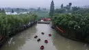 Foto dari udara ini menunjukkan warga desa yang berpartisipasi dalam kontes mendayung ember di Desa Quanxin, Kota Huzhou, Provinsi Zhejiang, China, Selasa (23/6/2020). Warga desa menggunakan ember purun tikus (water chestnut) saat memancing, dan mengumpulkan purun tikus serta lotus. (Xinhua/Xu Yu)