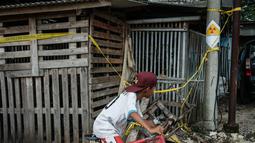 Sebuah stiker peringatan bertuliskan “Bahaya Radiasi” dengan catatan tulisan tangan yang menunjukkan “11,5 mikrosievert per jam” terlihat di salah satu tiang listrik di samping Kawasan Industri Modern Cikande, tempat isotop radioaktif Cesium-137  terdeteksi, di Sukatani, Banten pada 13 Oktober 2025. (Yasuyoshi CHIBA/AFP)
