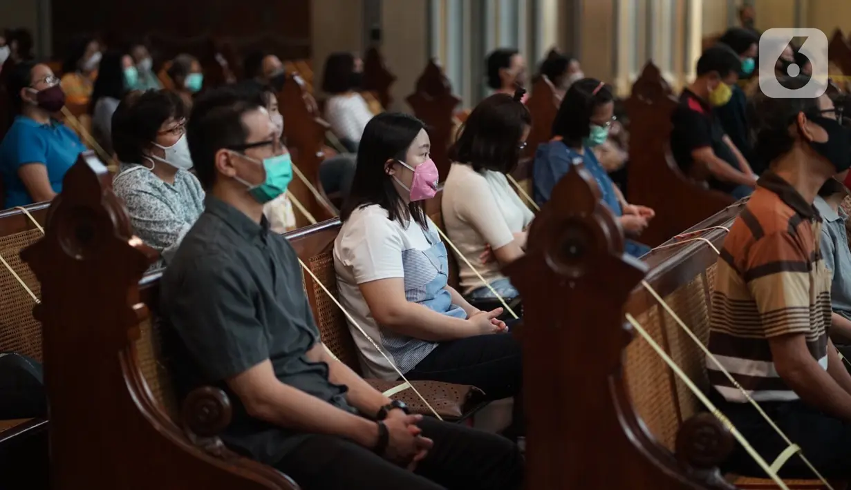 Jemaat duduk di antara pembatas jarak tubuh saat melaksanakan ibadah misa di Gereja Katedral Jakarta, Minggu (12/7/2020). Gereja Katedral Jakarta kembali menggelar misa bagi umat Katolik dengan menerapkan protokol kesehatan untuk mencegah penularan Covid-19. (Liputan6.com/Immanuel Antonius)