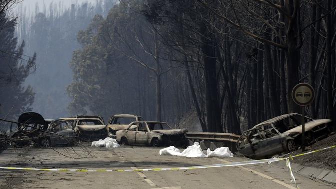 Mobil-mobil yang terbakar menghalangi jalan antara Castanheira de Pera dan Figueiro dos Vinhos, Portugal tengah, Minggu, 18 Juni 2017. (AP/Armando Franca),