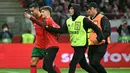 Pihak pengamanan menangkap seorang penyusup lapangan saat berusaha melakukan swafoto dengan pemain Portugal, Cristiano Ronaldo ketika laga lanjutan EUFA Nations League Polandia di National Stadium, Warsawa, Polandia, Minggu (13/10/2024) WIB. (AFP/Sergei Gapon)