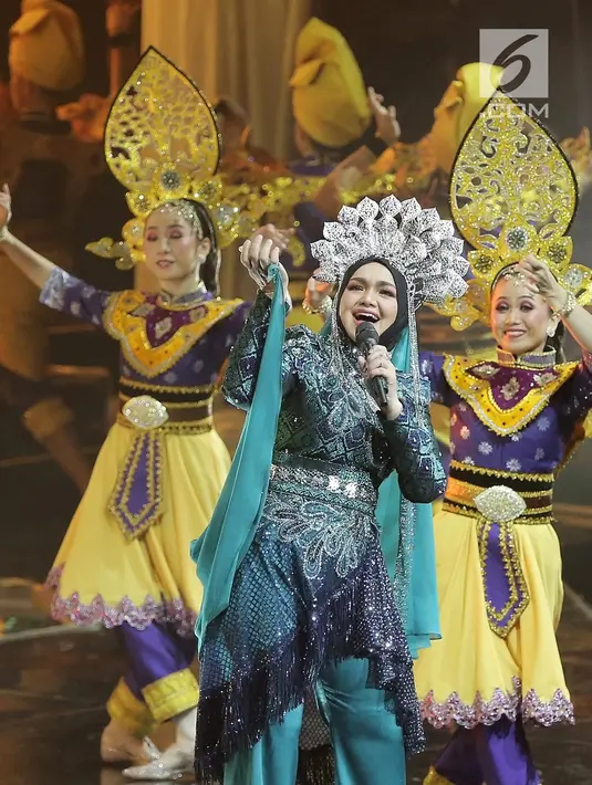 Penampilan penyanyi Siti Nurhaliza saat menggelar konser 'Dato Sri Siti Nurhaliza on Tour' di Istora Senayan, Jakarta, Kamis (21/2). Siti juga mengenakan sunting Melayu di kepalanya. (Fimela.com/Bambang E Ros)