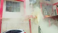 Petugas berusaha memadamkan api di gedung Telkomsel Pekanbaru yang terbakar. (Liputan6.com/Istimewa)
