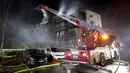 Petugas pemadam kebakaran memadamkan api di kompleks perumahan di Essen Jerman, Senin (21/2/2022). Sekitar 150 petugas dikerahkan untuk memadamkan api. (Roland Weihrauch/dpa via AP)