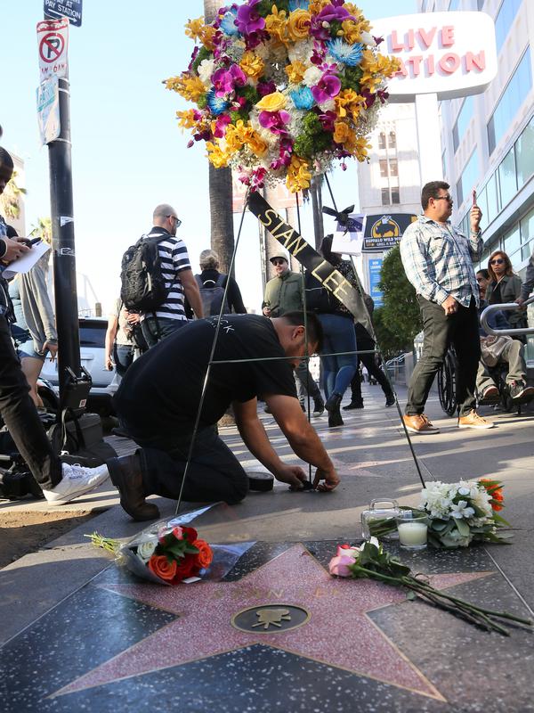 Penggemar meletakkan bunga dan memorabilia lainnya di atas bintang Walk of Fame milik pencipta sekaligus legenda komik-komik Marvel, Stan Lee di Hollywood, California, Senin (12/11). Stan Lee meninggal dunia pada usia 95. (Gabriel Olsen/Getty Images/AFP)