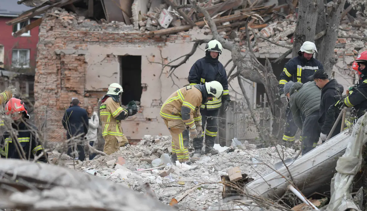Tim penyelamat mencari korban di reruntuhan rumah yang hancur akibat serangan roket Rusia di pinggiran Lviv, Ukraina, Minggu 5 Oktober 2025. (AP Photo/Mykola Tys)