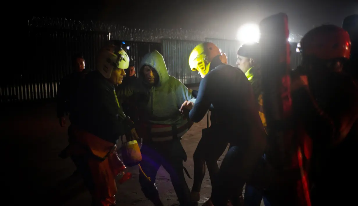 Pihak berwenang menahan seorang imigran Honduras yang diselamatkan dari air ketika berusaha menyeberangi perbatasan AS dari laut di pantai Tijuana, Meksiko, Kamis (29/11). (AP Photo/Ramon Espinosa)