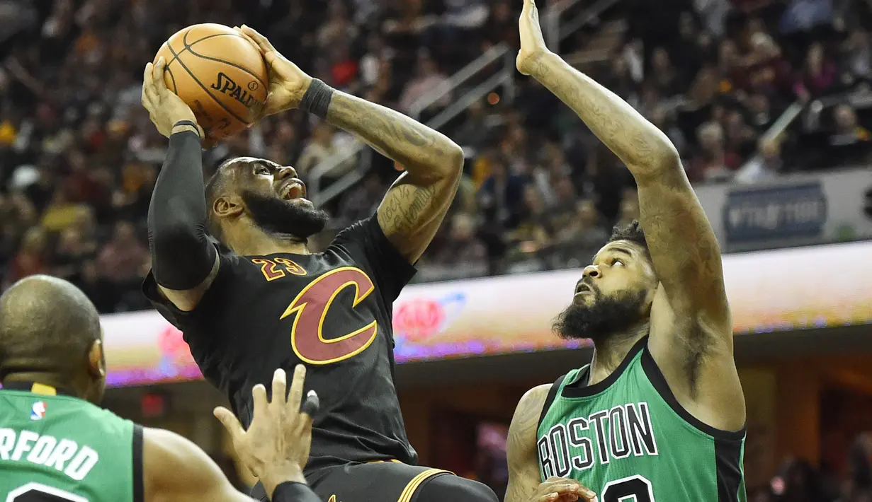 Pemain Cleveland Cavaliers, LeBron James (tengah) berusaha menjangkau basket saat dihadang para pemain Boston Celtics pada laga NBA di Quicken Loans Arena, (29/12/2016). (Reuters/Ken Blaze-USA TODAY Sports)