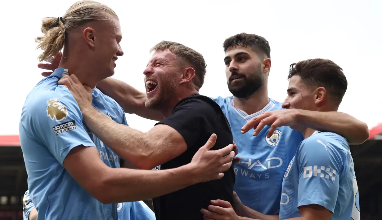 Kehadiran Terry Flanangan tak membuat Erling Haaland dan beberapa rekan satu timnya terganggu. Mereka terlihat menikmati momen kebahagian bersama walau tak berselang lama petugas keamanan langsung mengamankan sang pitch invader. (AFP/Darren Staples)