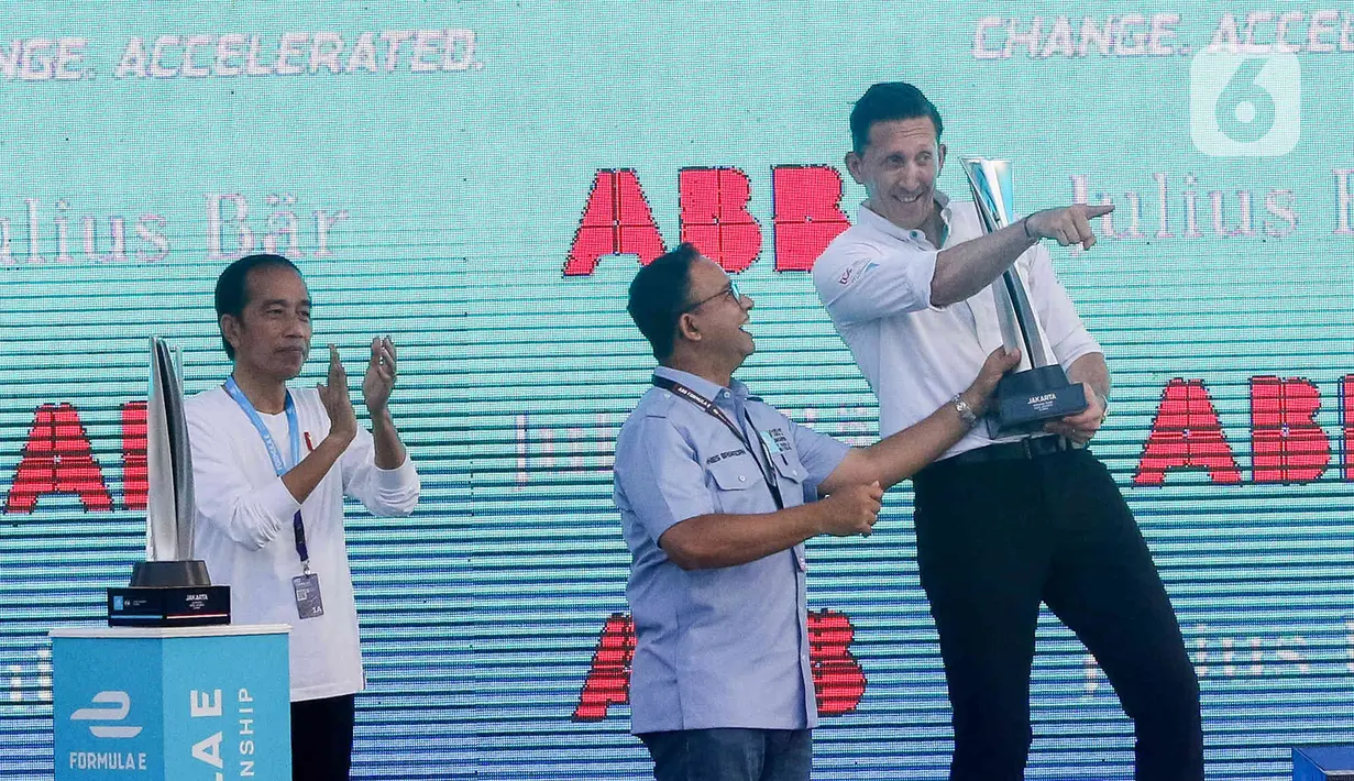 Presiden Joko Widodo atau Jokowi (kiri) bersama Gubernur DKI Jakarta Anies Baswedan (tengah) berada di atas panggung saat penyerahan piala Formula E di Jakarta International E-Prix Circuit (JIEC), Jakarta, Sabtu (4/6/2022). Andalan Jaguar TCS Racing Mitch Evans memenangkan ajang balap Formula E Jakarta e-Prix 2022. (Liputan6.com/Herman Zakharia)