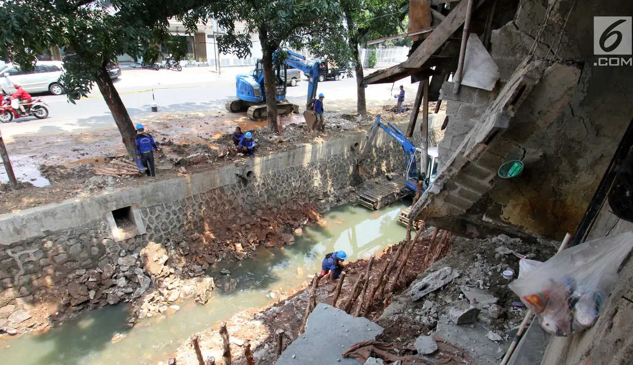 Pasukan biru dari Sudin SDA dibantu alat berat memperbaiki lokasi longsor di pinggir kali Bintaro Utara, Pesanggrahan, Jakarta, Kamis (20/9). Hujan deras yang melanda kawasan itu mengakibatkan lima rumah terkena longsor. (Liputan6.com/Angga Yuniar)