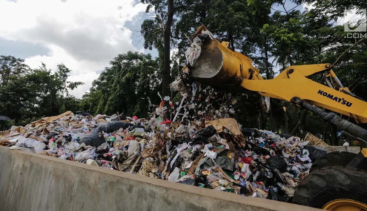 Petugas kebersihan dibantu alat berat membersihkan sampah Tahun Baru 2018 di Monas, Jakarta, Senin (1/1). Kepala Dinas Lingkungan Hidup (LH) DKI Jakarta, Isnawa Adji mengatakan adanya peningkatan jumlah sampah pada tahun ini. (Liputan6.com/Faizal Fanani)