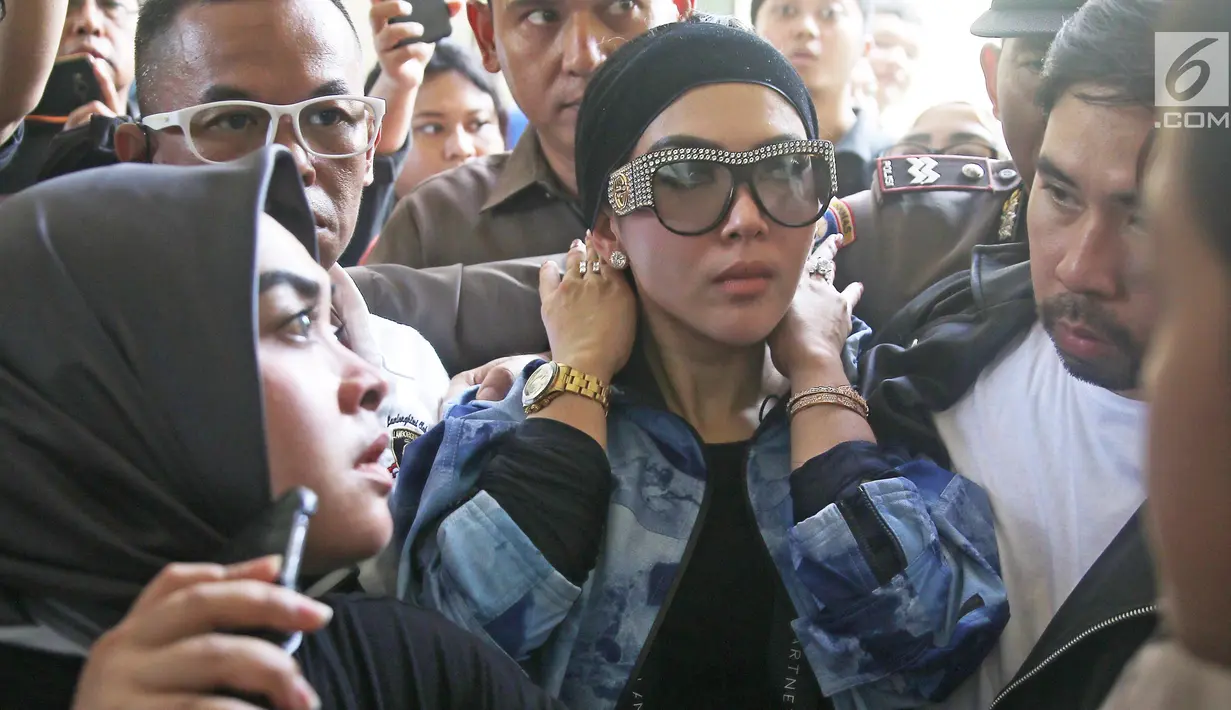 Penampilan penyanyi Syahrini saat mendatangi Pengadilan Negeri Depok untuk menjadi saksi di sidang kasus First Travel, Senin (2/4). Syahrini terlihat menggunakan jam tangan Rolex dan kacamata bertahtakan kristal dari Gucci. (Liputan6.com/Herman Zakharia)