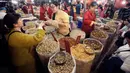 Pedagang melayani pembeli yang berbelanja untuk perayaan tahun Baru Imlek di pasar Dihua Street, Taipei di Taiwan, Selasa (22/1/2020). Orang-orang mulai berburu makanan lezat, kue kering, barang-barang murah lainnya di pasar menjelang Imlek pada 25 Januari mendatang. (AP Photo/Chiang Ying-ying)